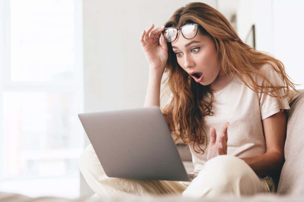 woman looking shocked at what she is seeing on her computer - Shocked lady using laptop computer.