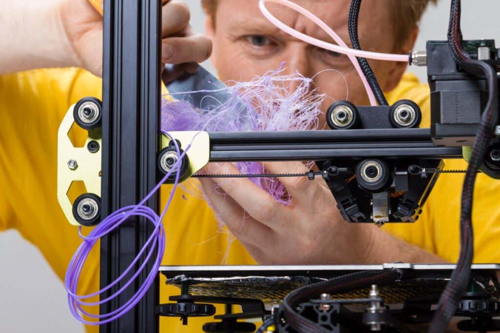 12 Troubleshooting Tips for 3D Filament Prints Gone Awry image - Man fighting with a 3D printer