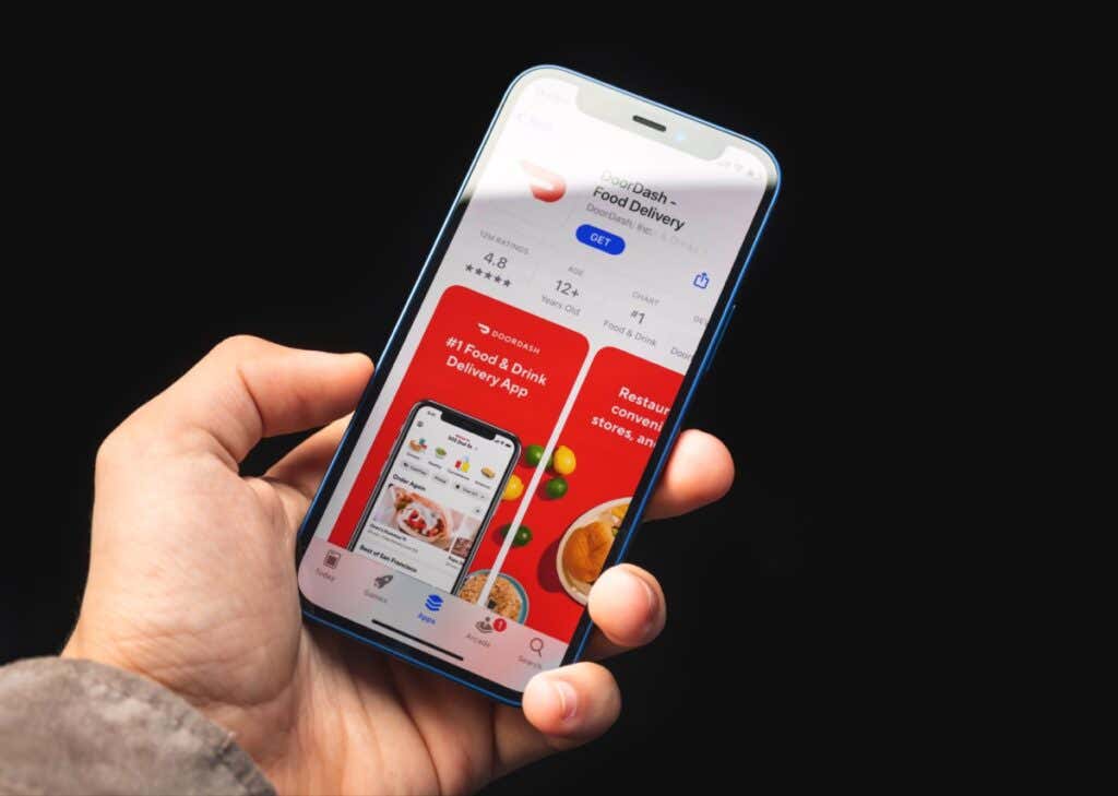 What Is DashPass and Is It Worth It? image - Kharkov, Ukraine - June 4, 2021: Doordash food delivery app, man holds mobile phone with application on the screen