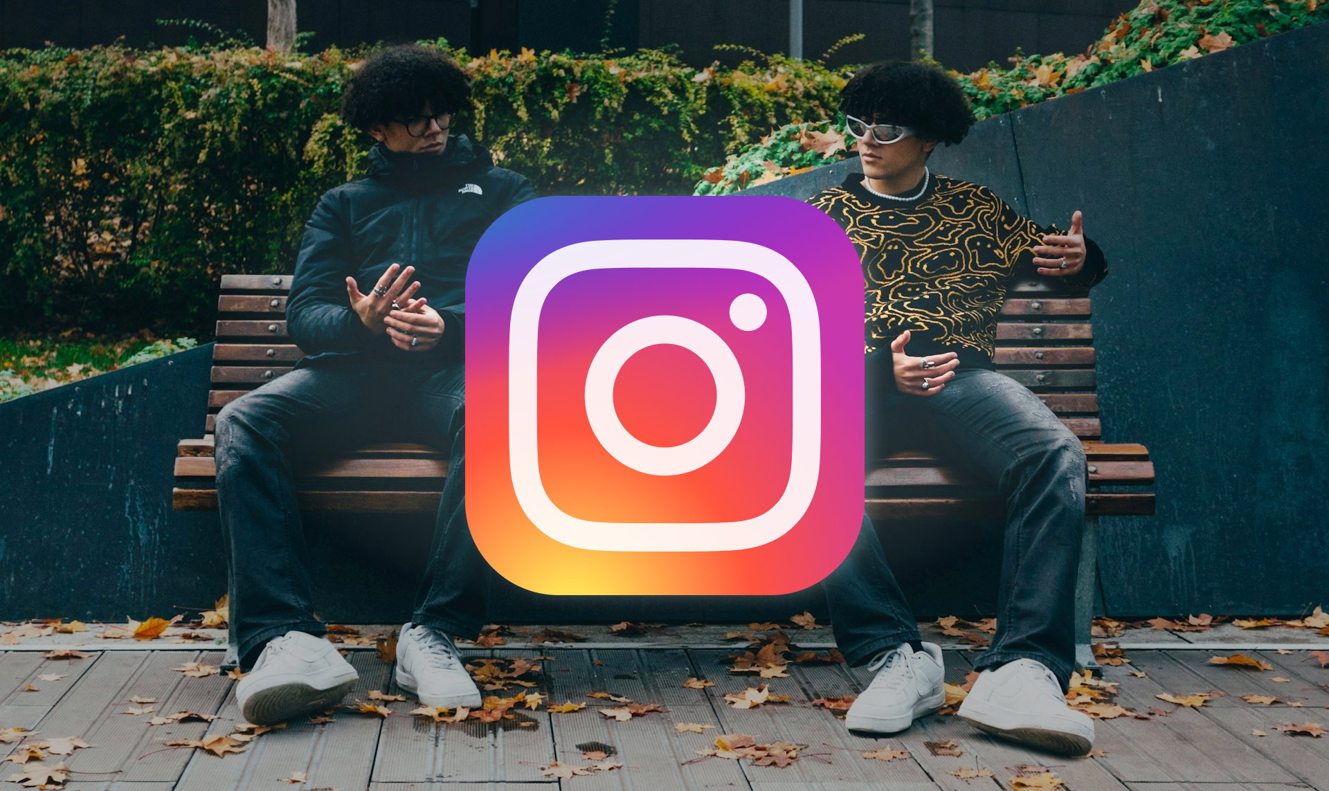 Two identical individuals sitting side-by-side on a bench with their faces obscured by a large Instagram logo icon - instagram-meta-ai-studio