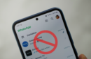An Android smartphone showing a list of WhatsApp conversations, overlayed by a red block icon - whatsapp-beta-block-messages-unknown-accounts