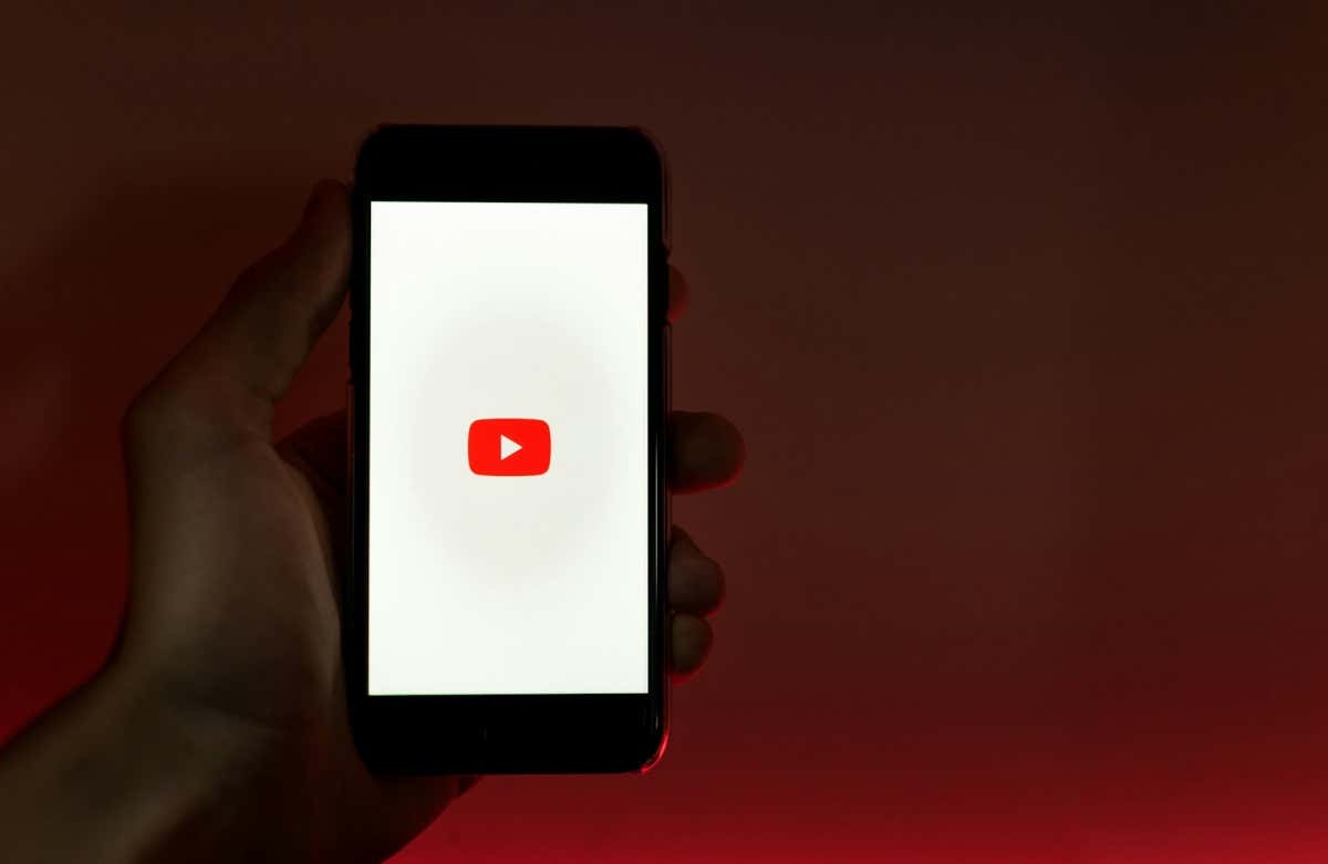 person holding smartphone displaying the YouTube logo